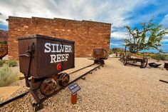 an old train sitting on the tracks in front of a brick building with a sign that says silver reef