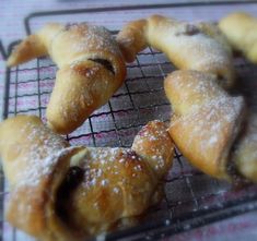 several pastries on a cooling rack with powdered sugar sprinkled on them