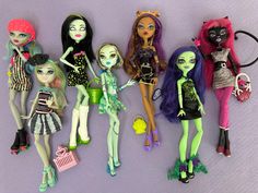 there are many dolls lined up together on the table and one is holding a purse