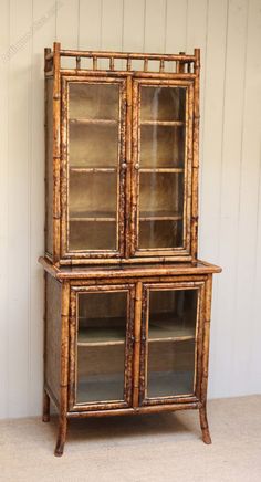 an old bamboo china cabinet with glass doors