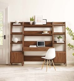 an office with a desk, chair and shelving unit in the middle of it