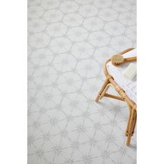 a white tiled floor with a wooden chair and towel on it's back end