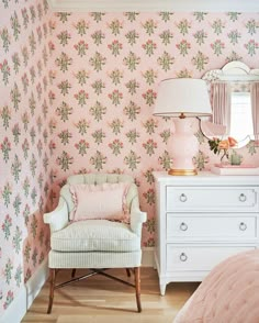 a bedroom with floral wallpaper and pink furniture