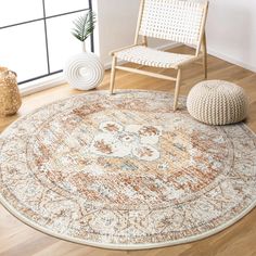 a large round rug with an ornate design on the floor in front of a chair