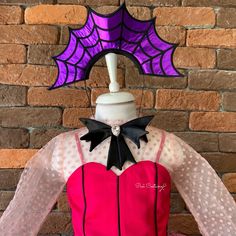 a mannequin dressed in pink and black with a purple spider web on top