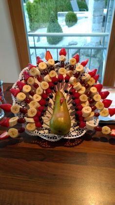 a fruit and veggie platter on a table in front of a window