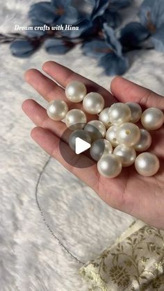 a person holding some pearls in their hand