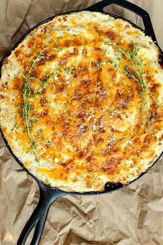 a pizza sitting on top of a frying pan covered in cheese and toppings