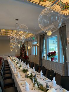 a long table is set up with place settings and decorations for a holiday party or celebration