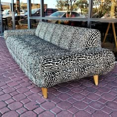 a zebra print couch sitting in front of a window