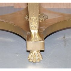 a close up view of the corner of a table with gold paint and ornate designs on it