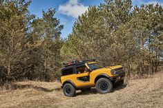 a yellow jeep is driving through the woods