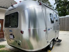 a silver trailer parked in front of a house