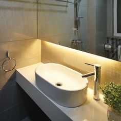 a bathroom sink sitting under a mirror next to a faucet mounted on a wall