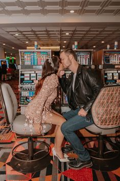 a man kissing a woman on the cheek while sitting in a chair at an airport