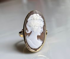 Cameo ring; 14k solid gold. The hand carving in this piece is unusually nice quality and is well preserved. Even the wavy tendrils of her hair and orange blossom crown are still visible. Shell cameo is bezel set and measures 25 mm x 14 mm. The ring shape elongates the finger and looks beautiful on the hand! Details: Ring face measures 25 mm x 14 mm. This is a wonderfully substantial piece! Size 6.5 and can be sized by adding our custom sizing listing to your cart using this link: https://www.ets Yellow Gold Cameo Ring Fine Jewelry, 14k Gold Cameo Ring Fine Jewelry, Oval Cameo Yellow Gold Ring, Oval Yellow Gold Cameo Ring, Victorian Yellow Gold Carved Rings, Victorian Carved Yellow Gold Rings, Luxury Yellow Gold Cameo Rings, Yellow Gold Cameo Rings For Gifts, Wedding Cameo Ring In Yellow Gold