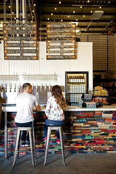 two people sitting at a bar with lots of books