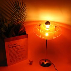 a lamp that is on top of a table next to a sign with the words le me en apper