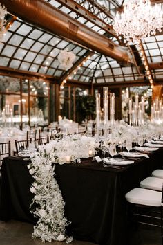 the tables are set with white flowers, candles and centerpieces for an elegant reception