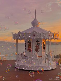 a white carousel with bubbles floating in the air