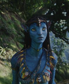 a woman with blue skin and makeup is standing in the woods