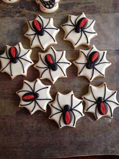 decorated cookies arranged in the shape of spider's webs on a wooden table