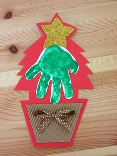 a handprinted christmas tree on top of a wooden table