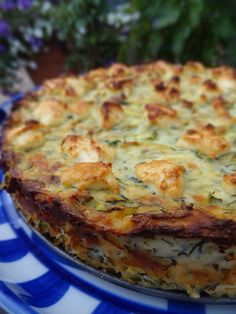 a blue and white plate topped with a cheesy dish