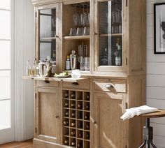 a wooden cabinet filled with lots of bottles and glasses