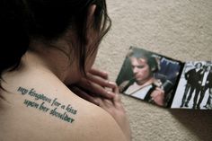 a woman with a small tattoo on her back shoulder next to an album and two photos