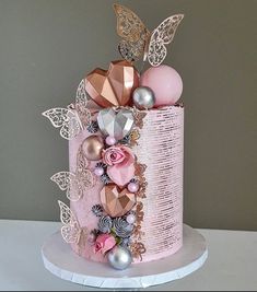 a pink and gold decorated cake sitting on top of a table