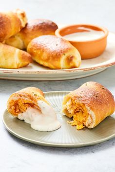 two plates filled with pastries and dipping sauce