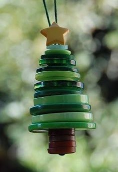 a green christmas tree with a star on it's top hanging from a string