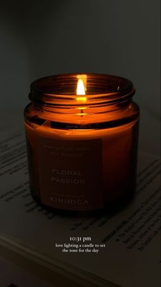 a candle that is sitting on top of a book with the words floral passion written in it