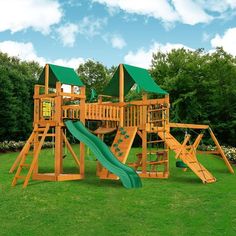 a wooden playset with green slides and trees in the backgroung area