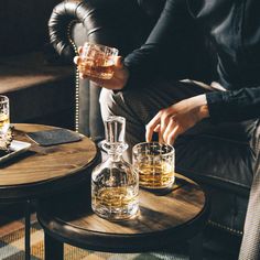 a man sitting at a table with two glasses on top of it and another glass in front of him