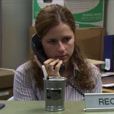 a woman sitting at a desk talking on the phone