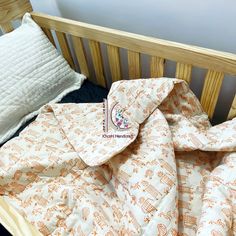 an unmade crib with a blanket on top of it next to a pillow