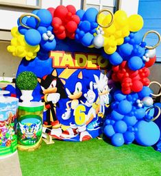 an arch decorated with balloons and mickey mouse characters