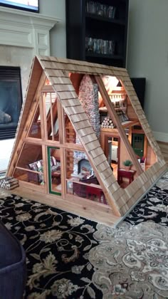 a doll house made out of wood with windows on the top and bottom floor is shown