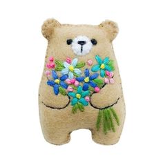 a teddy bear with flowers on it's chest