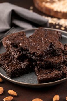 some brownies are on a plate with almonds