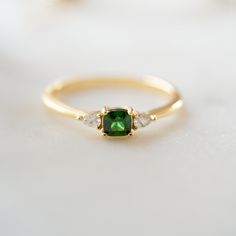 Sweet, simple, and dainty emerald ring. Perfect for a minimalist look, or for stacking. It adds a fun pop of color to your look! Featuring a cushion cut stone with pear stones adorning both sides - making this a delicate and beautiful ring!Emerald rings are said to represent luck, love, peace, and hope. Made of 925 Sterling Silver Available in 14k Gold or Rhodium Plating We use a THICK 14k Gold plating - for a piece that will last you years to come! VERY HIGH QUALITY Made of the highest grade of Elegant Adjustable Emerald Ring, Elegant Everyday Adjustable Emerald Ring, Minimalist Cushion Cut Ring As Gift, Layering Diamond Necklaces, Emerald Rings, Yellow Rings, Cushion Ring, Square Stone, Ring Emerald