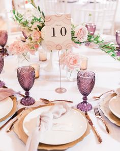 the table is set with plates, silverware and napkins for an elegant wedding reception