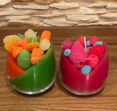 two bowls filled with candy and candies on top of a wooden table