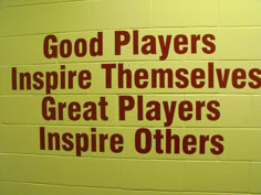 there is a sign on the wall that says good players inspire themselves great players inspire others