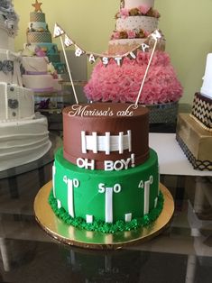 three tiered cake decorated with footballs and pink tulle for a baby's first birthday