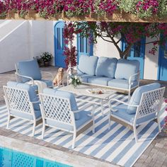 a patio with blue and white furniture next to a swimming pool