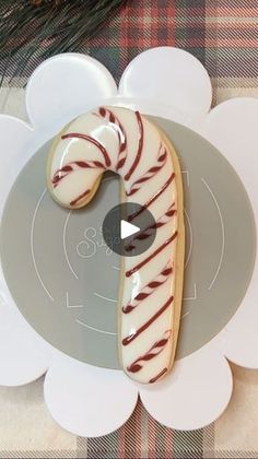 a white plate topped with a candy cane cookie on top of a flower shaped platter