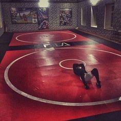 a man is standing on one leg in the middle of a wrestling ring with another person